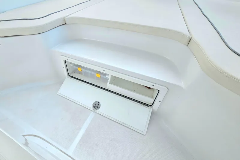 Slide: The Image of 2023 Sea Hunt BX 25 FS boat storage compartment with open hatch and seating area. - 14