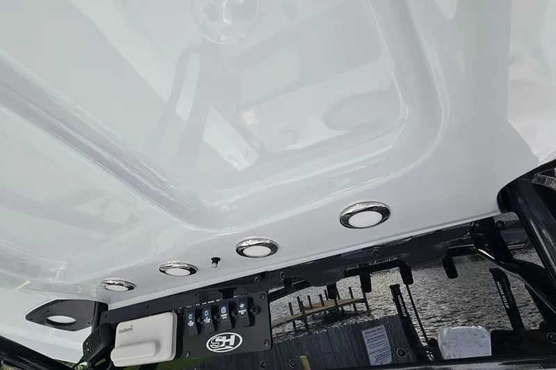 Slide: The Image of 2023 Sea Hunt BX 25 FS boat console with controls and lighting, dockside view. - 18