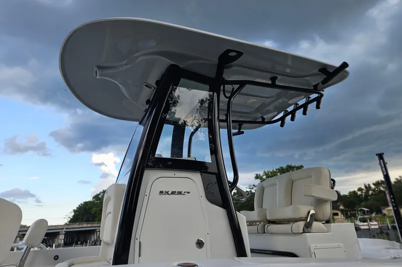 Slide: The Image of 2023 Sea Hunt BX 25 FS boat with T-top and seating, under cloudy sky. - 2