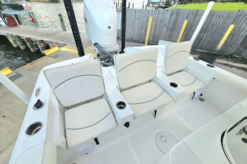 Slide: The Image of 2023 Sea Hunt BX 25 FS boat with three cushioned seats and outboard motor at dock. - 20