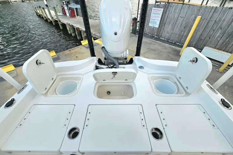Slide: The Image of 2023 Sea Hunt BX 25 FS boat deck with storage compartments and motor at dock. - 21