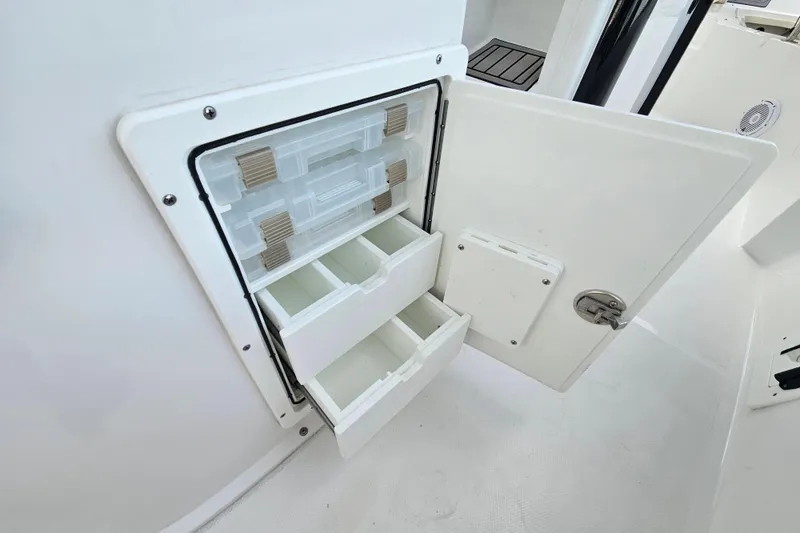 Slide: The Image of 2023 Sea Hunt BX 25 FS boat storage compartment with open drawers and tackle boxes. - 28