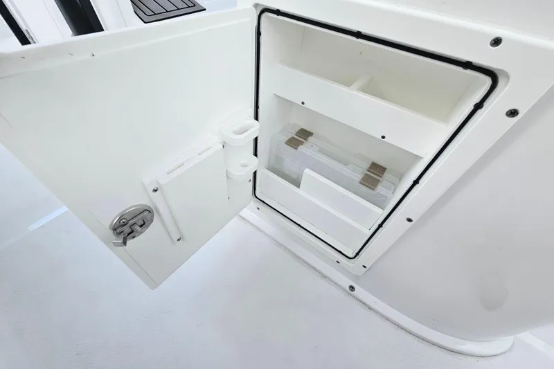 Slide: The Image of 2023 Sea Hunt BX 25 FS boat storage compartment with open door and organized shelves. - 29