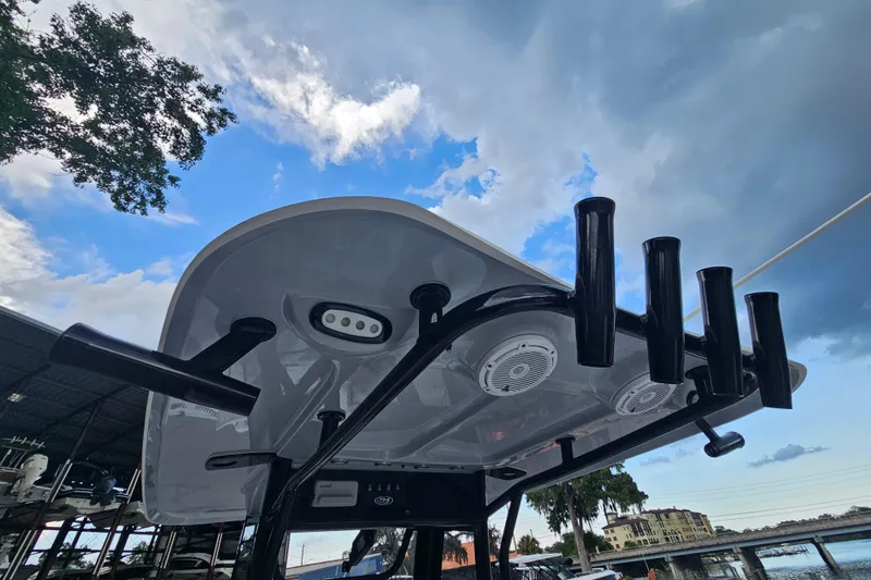 Slide: The Image of 2023 Sea Hunt BX 25 FS boat with rod holders and speakers under a cloudy sky. - 30