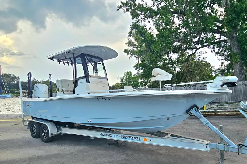 Slide: The Image of 2023 Sea Hunt BX 25 FS boat on trailer, parked near water under cloudy sky. - 9