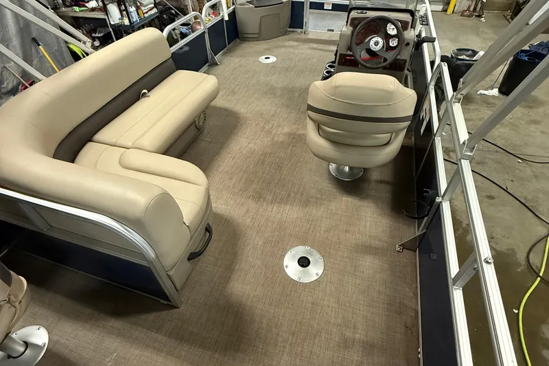 Slide: The Image of 2023 Sun Tracker Bass Buggy 18 DLX interior with beige seating and steering console. - 10