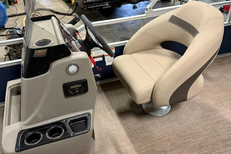 Slide: The Image of 2023 Sun Tracker Bass Buggy 18 DLX helm with beige captain's chair and control panel. - 12