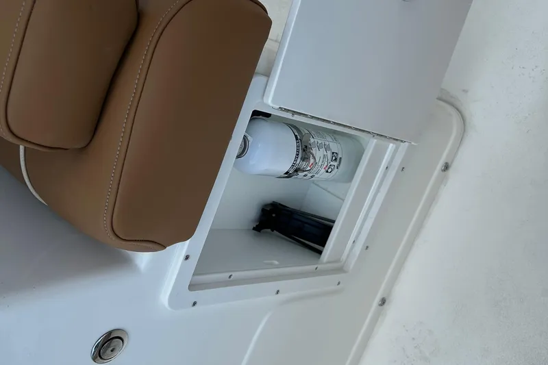 Slide: The Image of Storage compartment on 2026 Key West 239 FS boat with fire extinguisher and brown seat. - 16