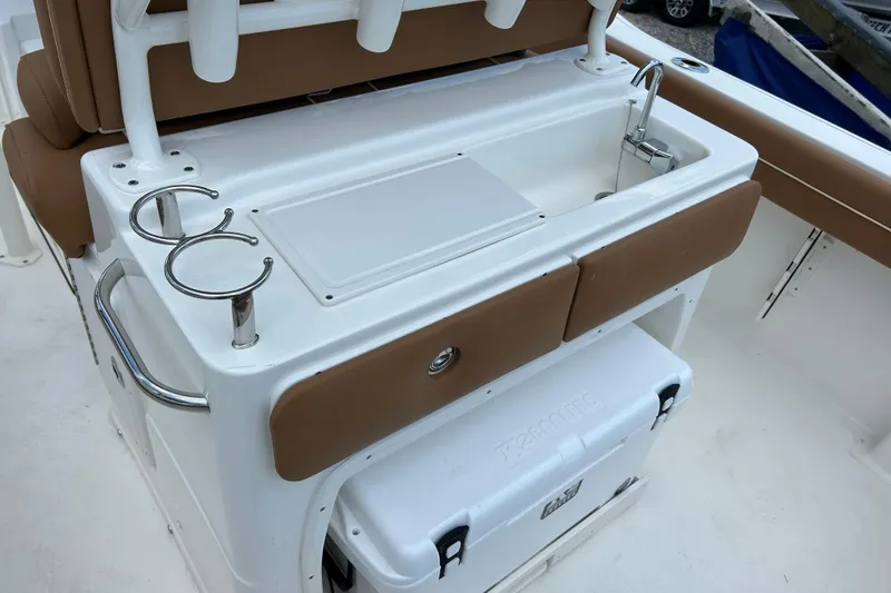 Slide: The Image of 2026 Key West 239 FS boat interior with sink, cup holders, and cooler storage. - 8