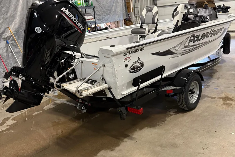 Slide: The Image of 2024 Polar Kraft Outlander 186 SC boat with Mercury engine on trailer in garage. - 3