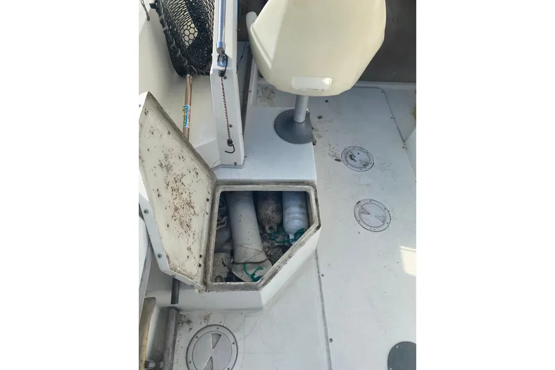 Slide: The Image of 1984 Hydra-Sports 2250 WA boat interior with open storage compartment and fishing gear. - 11