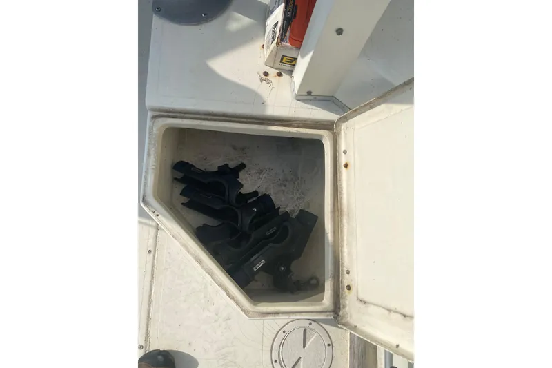Slide: The Image of Open storage compartment on 1984 Hydra-Sports 2250 WA boat, containing black equipment. - 13