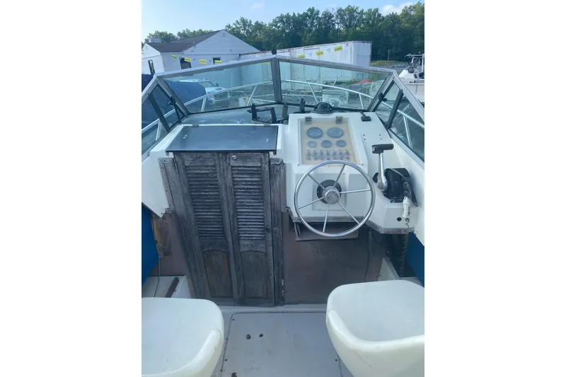 Slide: The Image of 1984 Hydra-Sports 2250 WA boat cockpit with steering wheel and control panel. - 2