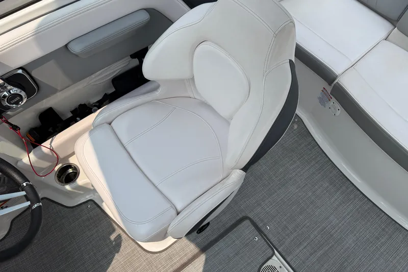 Slide: The Image of 2020 Chaparral 21 Surf boat interior with white captain's chair and dashboard. - 19