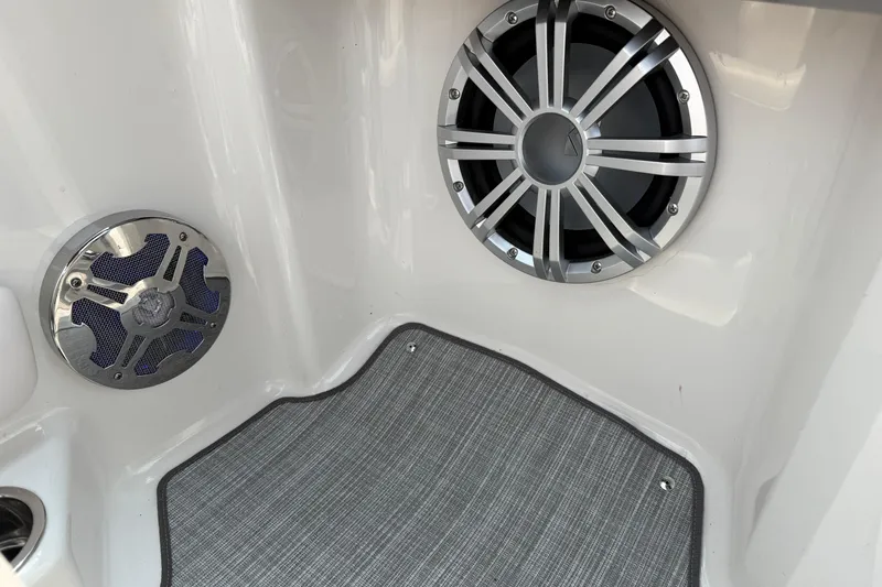 Slide: The Image of 2020 Chaparral 21 Surf boat interior with premium speakers and carpeted flooring. - 23