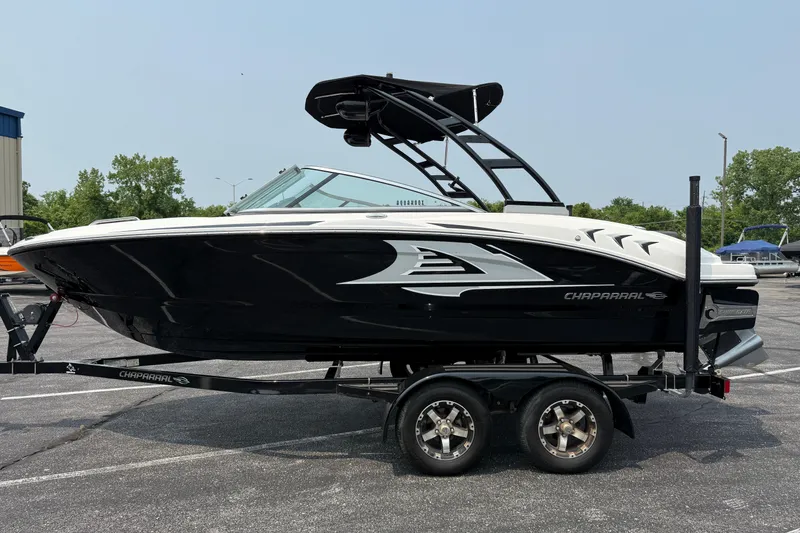 Slide: The Image of 2020 Chaparral 21 Surf boat on trailer, black and white design, parked outdoors. - 3