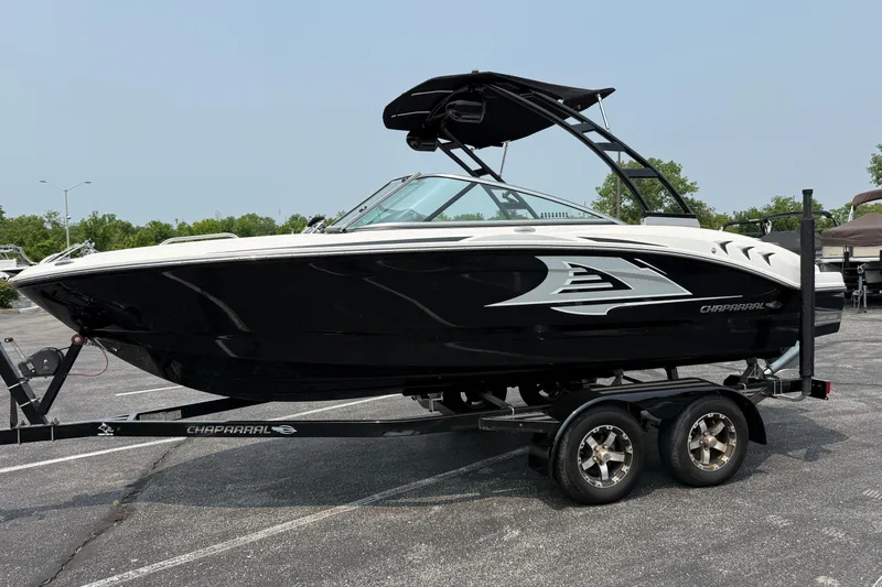 Slide: The Image of 2020 Chaparral 21 Surf boat on trailer, black and white design, parked outdoors. - 6