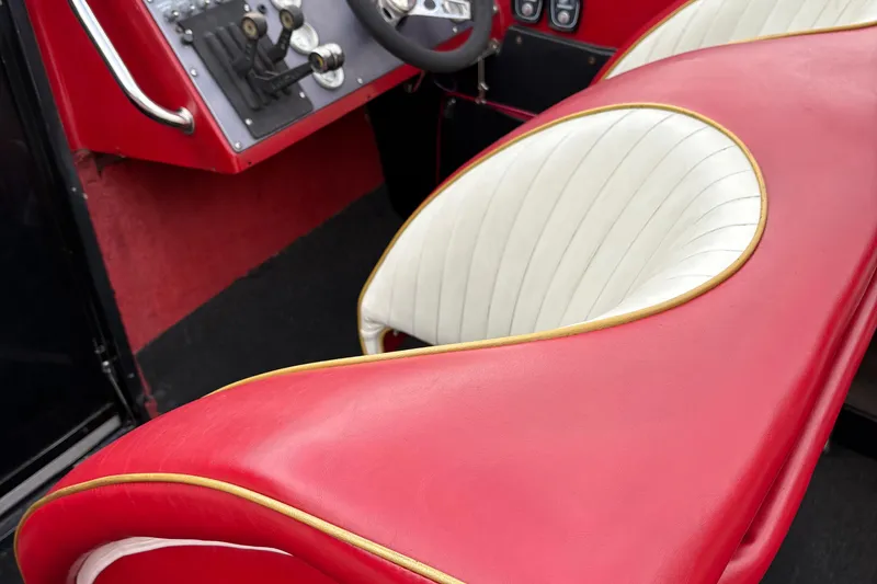 Slide: The Image of Red and white interior of a 1988 Fountain 38 boat, featuring sleek design and controls. - 4