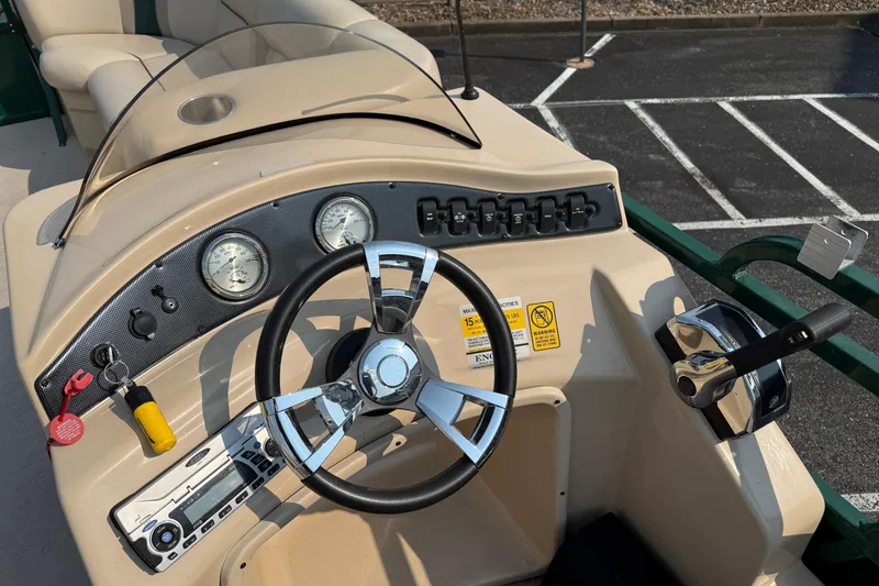 Slide: The Image of 2012 Bentley Pontoons 220 Cruise dashboard with steering wheel and control panel. - 13