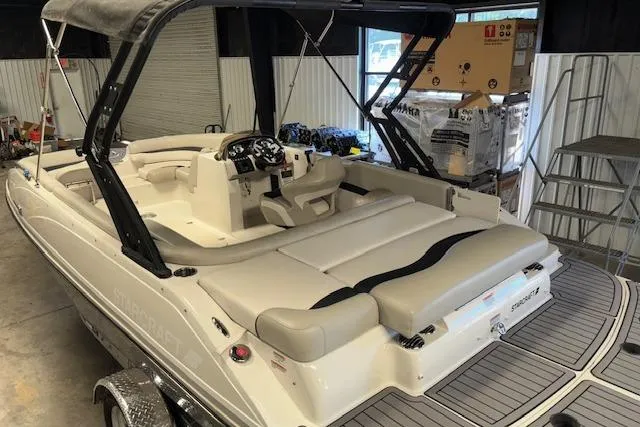 Slide: The Image of 2022 Starcraft Starstep 221 boat with seating, canopy, and control panel in a storage area. - 14