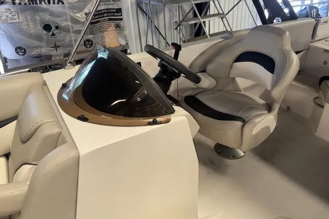 Slide: The Image of 2022 Starcraft Starstep 221 boat interior with steering wheel and cushioned seating. - 19