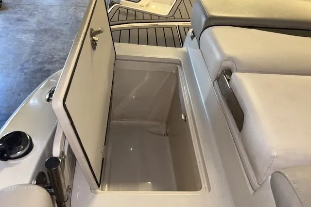 Slide: The Image of 2022 Starcraft Starstep 221 boat storage compartment with open lid and cushioned seating. - 26