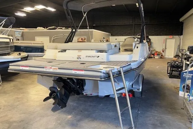 Slide: The Image of 2022 Starcraft Starstep 221 boat in indoor storage, rear view with ladder and motor. - 6