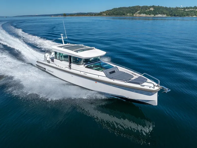The Image of 2021 Axopar Cross Cabin boat cruising on calm blue water. - 0