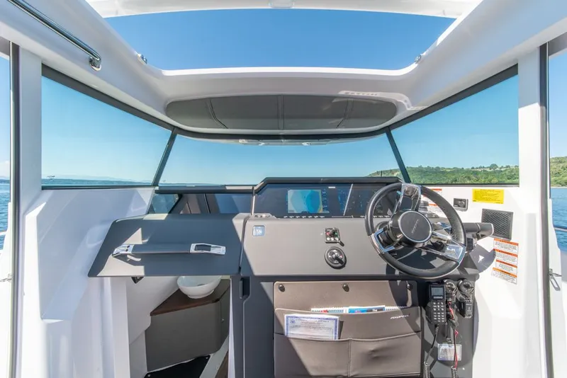Slide: The Image of 2021 Axopar Cross Cabin helm with modern controls and panoramic view. - 19
