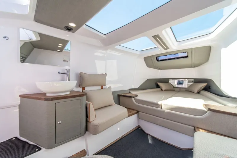 Slide: The Image of 2021 Axopar Cross Cabin interior with modern seating, bed, and skylights. - 23