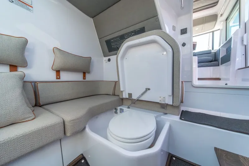 Slide: The Image of 2021 Axopar Cross Cabin interior with seating and compact marine toilet. - 24