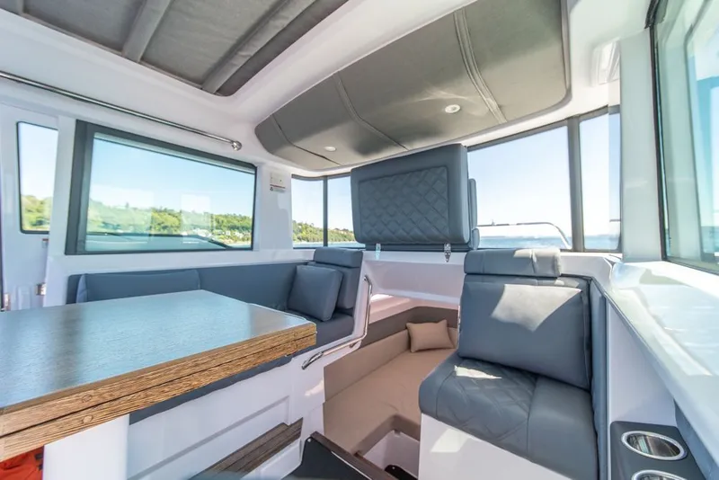 Slide: The Image of Interior of 2021 Axopar Cross Cabin boat with modern seating and large windows. - 25