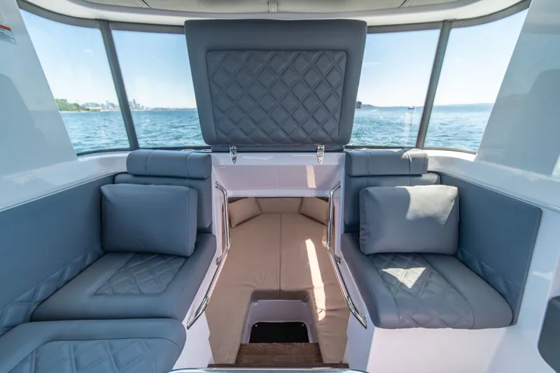 Slide: The Image of 2021 Axopar Cross Cabin interior with cushioned seating and ocean view. - 26