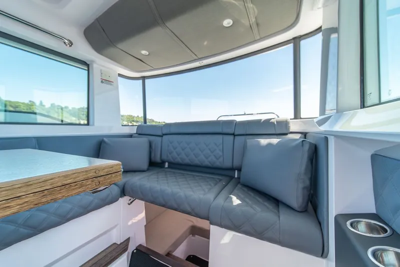 Slide: The Image of Luxurious interior of 2021 Axopar Cross Cabin with plush seating and panoramic windows. - 27