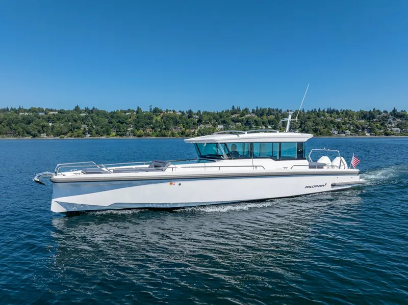 Slide: The Image of 2021 Axopar Cross Cabin boat cruising on a clear blue lake. - 3