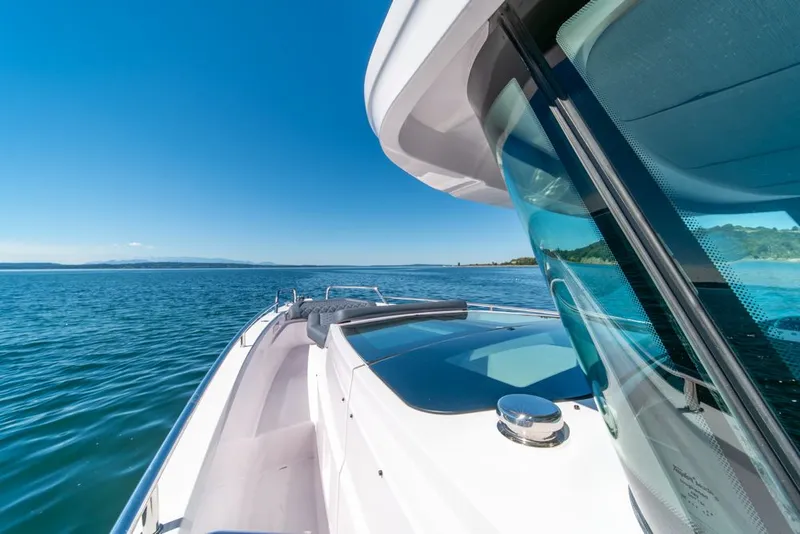 Slide: The Image of 2021 Axopar Cross Cabin boat cruising on a clear blue sea under a sunny sky. - 30
