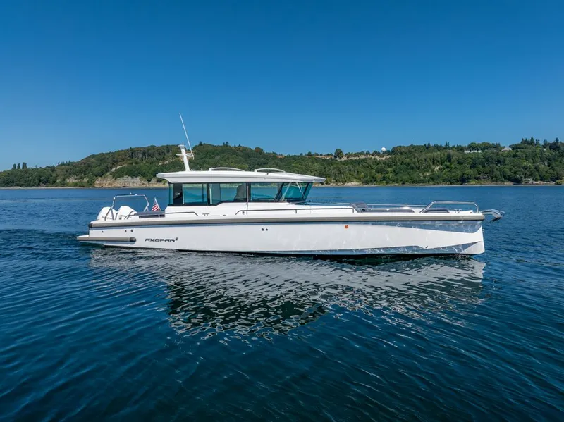 Slide: The Image of 2021 Axopar Cross Cabin boat on calm water with scenic background. - 4