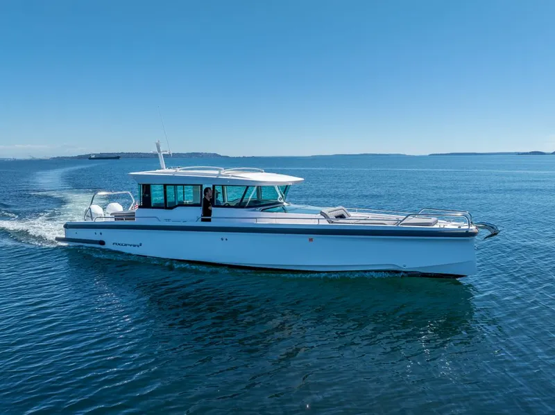 Slide: The Image of 2021 Axopar Cross Cabin boat cruising on open water under clear blue skies. - 43