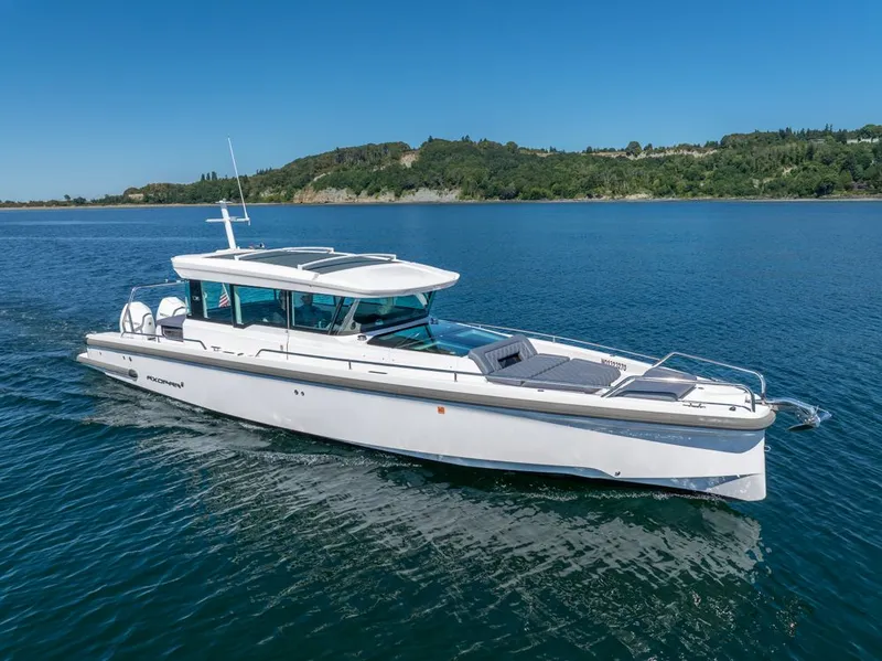 Slide: The Image of 2021 Axopar Cross Cabin boat cruising on a serene blue lake. - 46