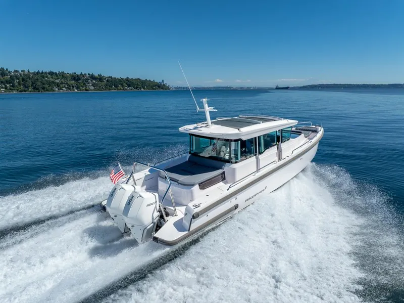 Slide: The Image of 2021 Axopar Cross Cabin boat cruising on a clear blue lake. - 49