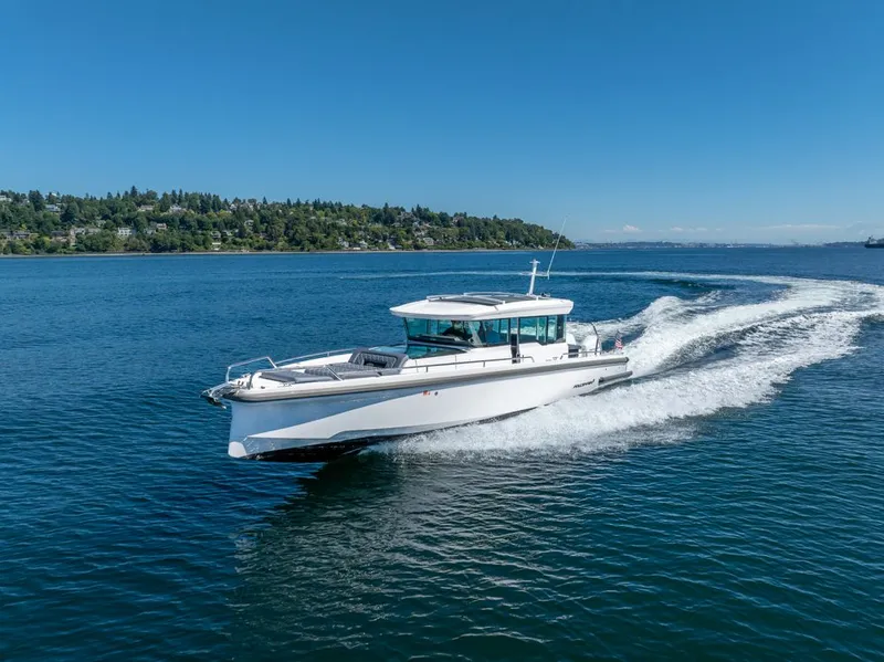 Slide: The Image of 2021 Axopar Cross Cabin boat cruising on a clear blue lake. - 7