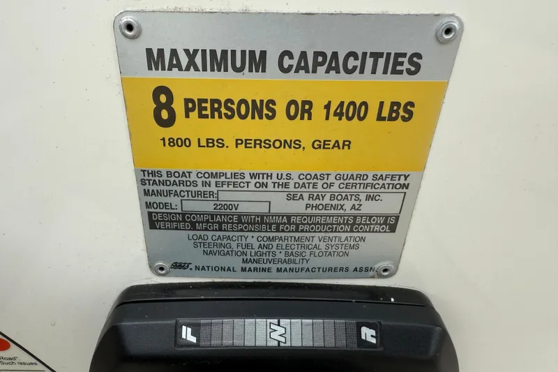 Slide: The Image of 1995 Sea Ray 220 Cuddy Cabin capacity plate, 8 persons or 1400 lbs, safety compliance. - 12