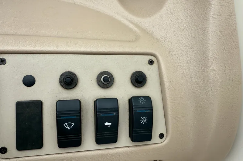 Slide: The Image of Control panel of a 1995 Sea Ray 220 Cuddy Cabin boat with switches and knobs. - 16