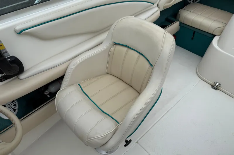 Slide: The Image of 1995 Sea Ray 220 Cuddy Cabin interior with cream seating and teal accents. - 19