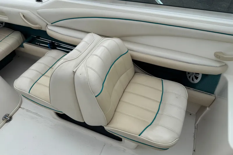 Slide: The Image of 1995 Sea Ray 220 Cuddy Cabin interior with white leather seating and teal accents. - 20