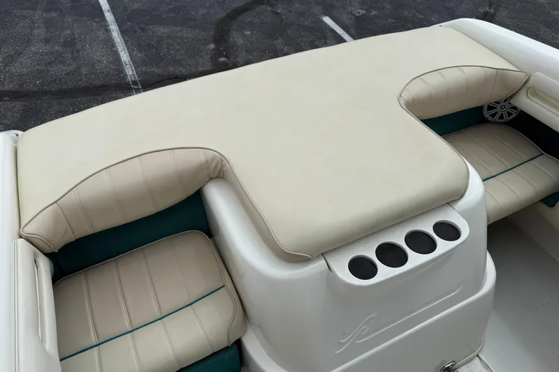 Slide: The Image of 1995 Sea Ray 220 Cuddy Cabin boat interior with beige seating and cup holders. - 27