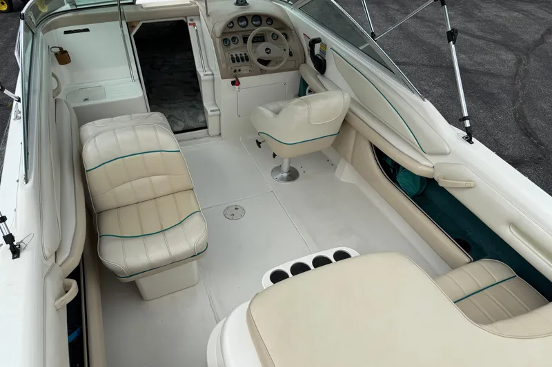 Slide: The Image of 1995 Sea Ray 220 Cuddy Cabin interior with white seating and steering console. - 28