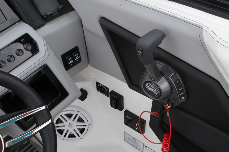 Slide: The Image of Interior controls of 2025 Cobalt R8 Surf boat, featuring steering wheel and throttle lever. - 23