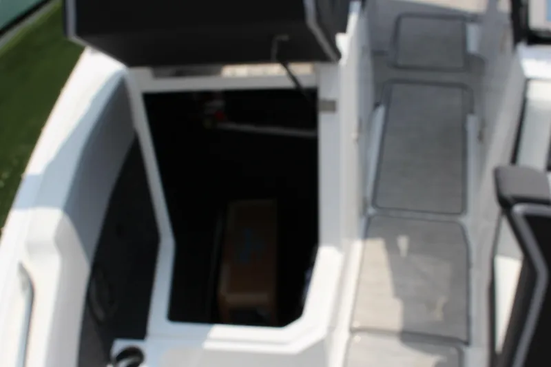 Slide: The Image of 2025 Cobalt R8 Surf boat interior with open storage compartment and seating area. - 27