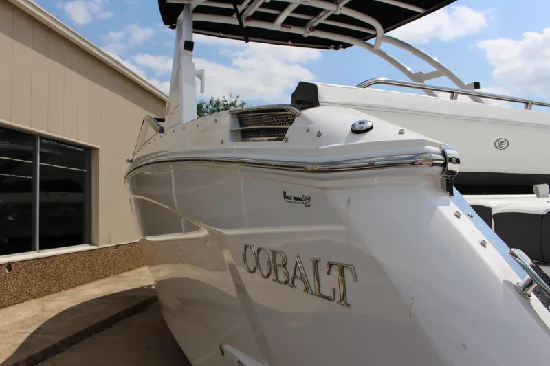 Slide: The Image of 2025 Cobalt R8 boat with sleek design, docked near a building under a blue sky. - 10